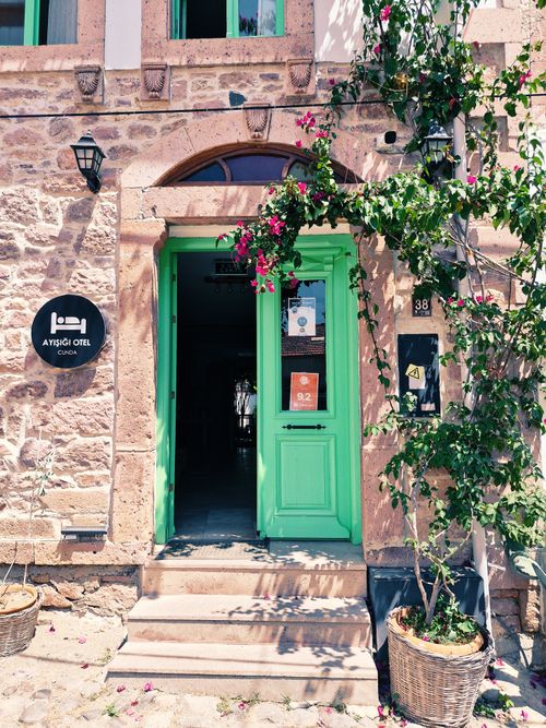 Free Vintage hotel entrance with green door and flowers, Balıkesir, Türkiye. Stock Photo
