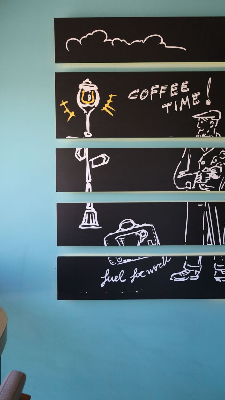 Small framed coffee-themed wall art hung on the wall beside a cozy office coffee bar
