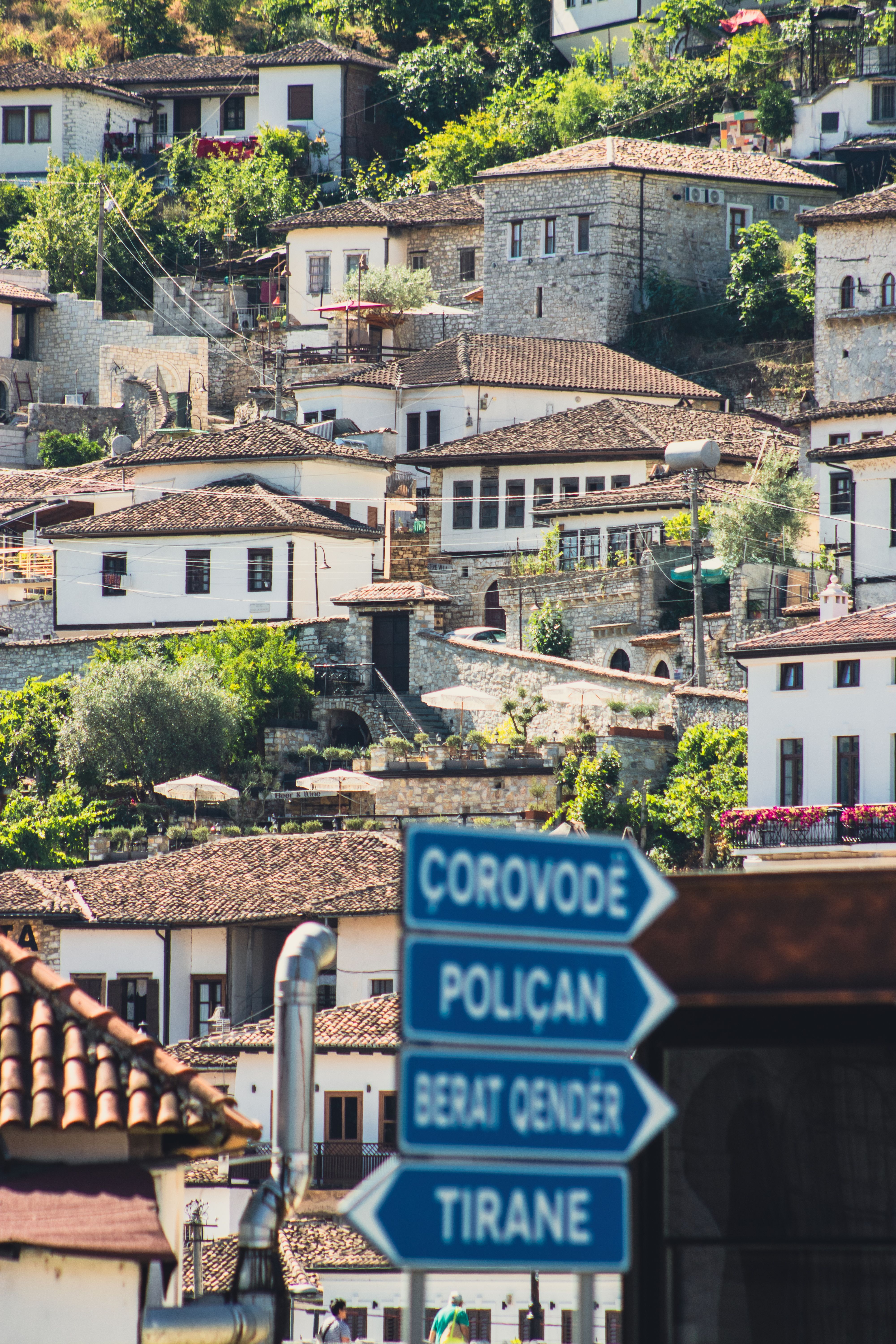 Traditional stone houses in Berat, Albania, capture the essence of Ottoman architecture amidst lush greenery.