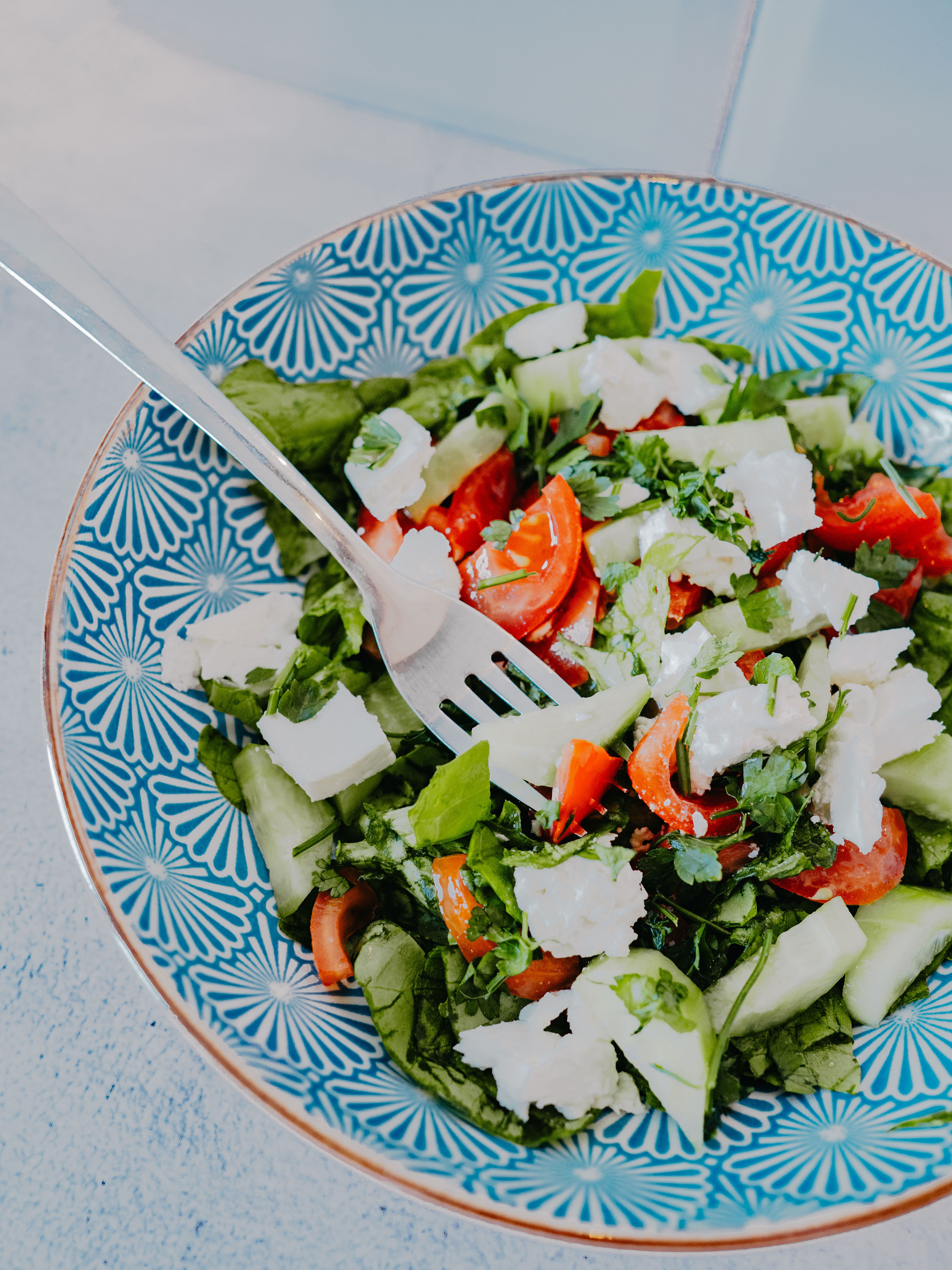 Vibrant Greek salad with fresh vegetables and feta cheese in a patterned bowl.