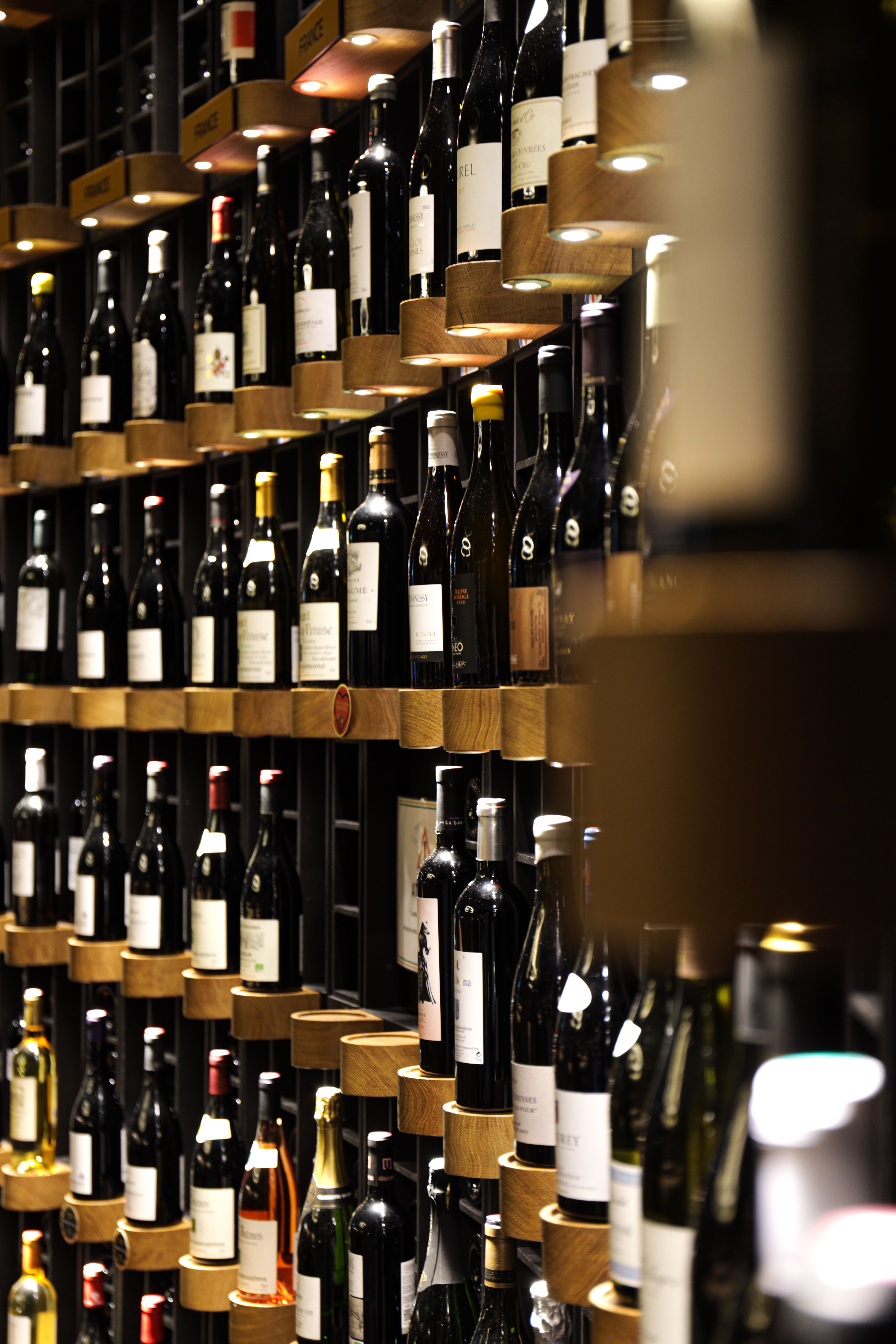 Luxurious wine cellar with assorted wine bottles in a Bordeaux restaurant, showcasing elegant shelving design.