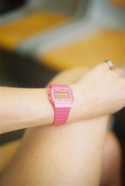 Vibrant pink digital watch on a wrist captured in Lisbon, Portugal.