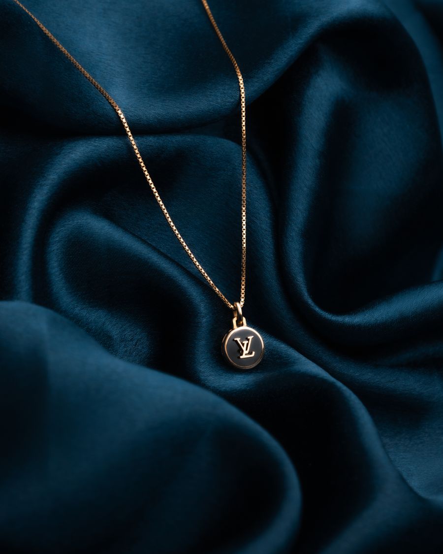 Gold pendant necklace on deep blue silk