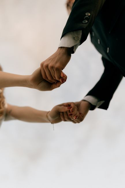 Fotomural Primer plano de una pareja tomados de la mano, simbolizando amor y unidad, vestidos con vestimenta de boda.