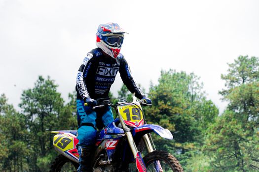 Dynamic shot of a motocross rider speeding through a forest trail in Mexico.