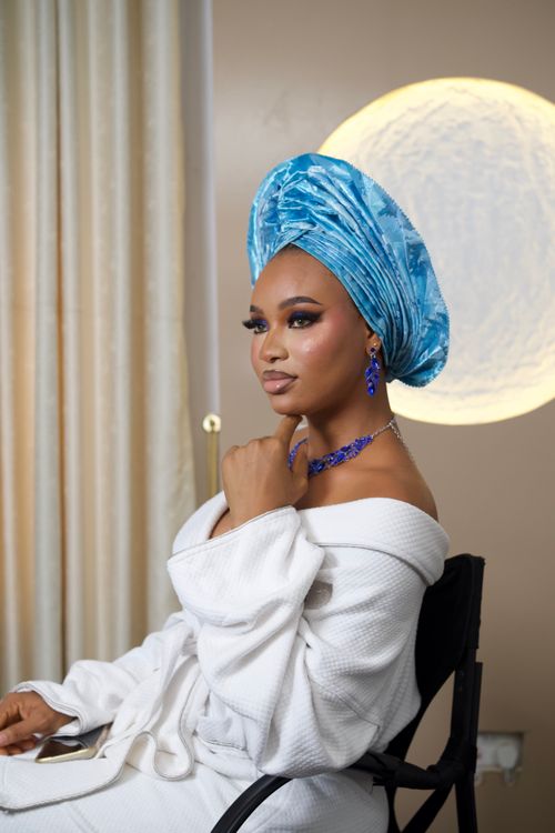 Free Stunning studio portrait of a woman in a blue gele and elegant jewelry, exuding beauty and sophistication. Stock Photo