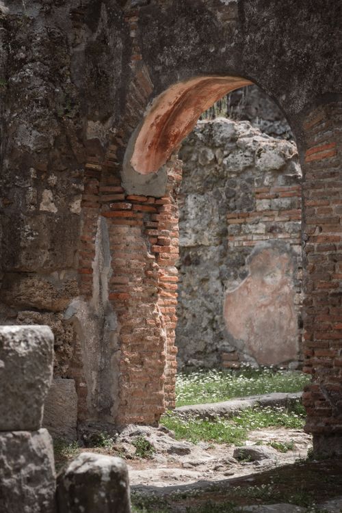 Free Explore an ancient Roman stone archway with historical brickwork and overgrown nature. Stock Photo