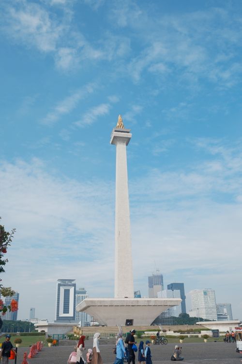 Free The iconic National Monument in Jakarta, Indonesia, adorned by a clear blue sky and bustling visitors. Stock Photo