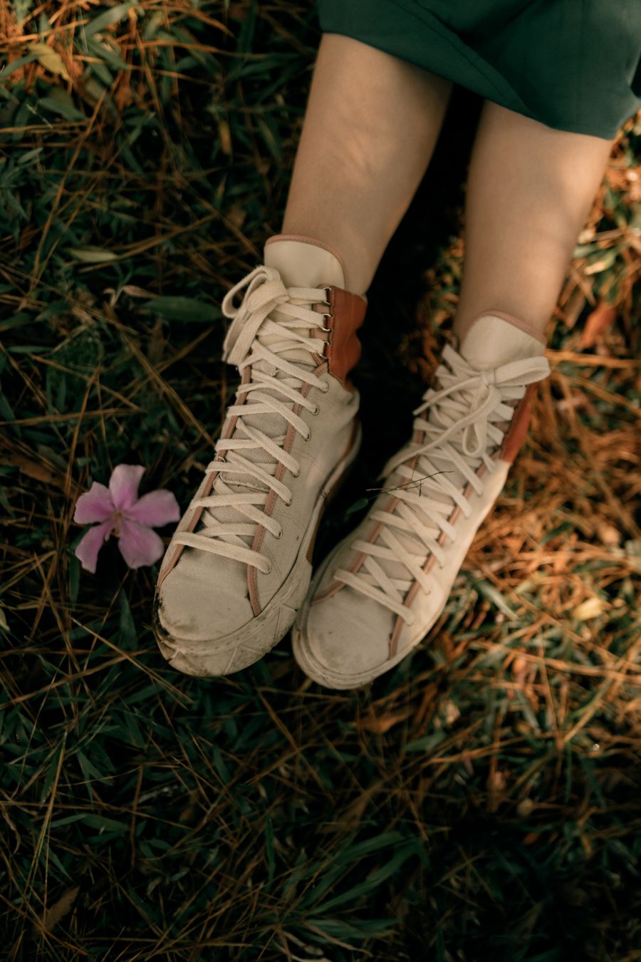 Beige canvas high-top sneakers on grass