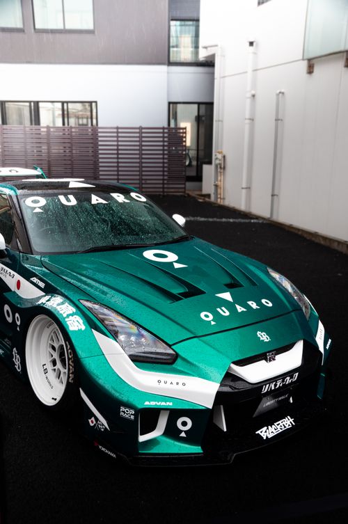 Free Green Nissan sports car with custom design parked in Tokyo streets, showcasing modern automotive art. Stock Photo