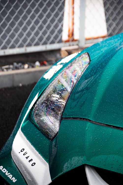 Free Detail shot of a modern sports car with raindrops in Tokyo, showcasing sleek design and vibrant color. Stock Photo
