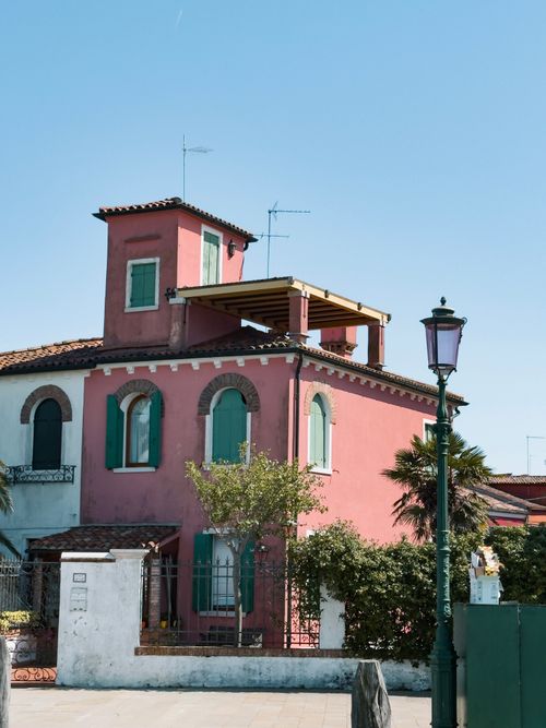 Free A vibrant pink house with green shutters in Venice, displaying unique Italian architecture on a sunny day. Stock Photo