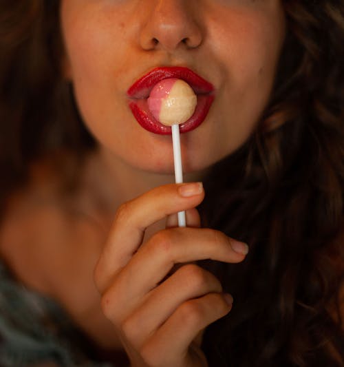 Woman With Red Lipstick Sucking on Red Lollipop