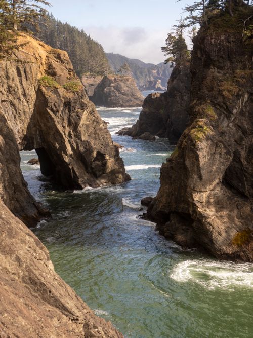 Free Dramatic view of Oregon's rugged coastline featuring striking rock formations and flowing waters. Stock Photo