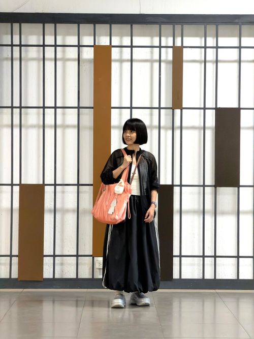 Free Young woman posing indoors with modern fashion style and large pink bag, contemporary backdrop. Stock Photo