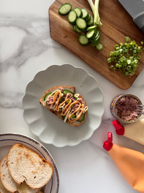 Free Delicious open-faced tuna sandwich with cucumber, green onions, and mayo on a decorative plate. Stock Photo