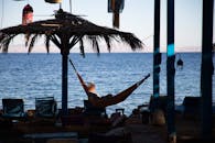 黄昏时分，女人在海边的吊床上享受休闲时光