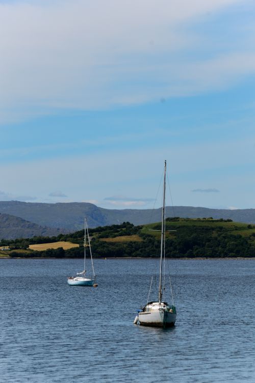 Free Serene view of sailboats on Bantry Bay, Ireland, with rolling hills and blue sky. Stock Photo