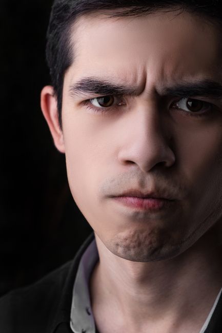 Fotomural Retrato en primer plano de un hombre adulto intenso y serio con expresión concentrada.