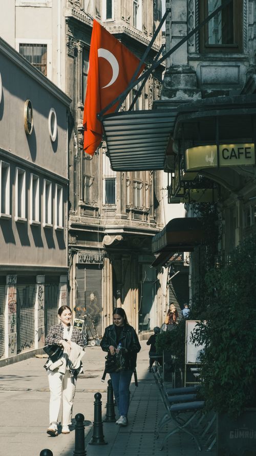 Free Charming Istanbul street scene featuring Turkish flag and local pedestrians. Stock Photo
