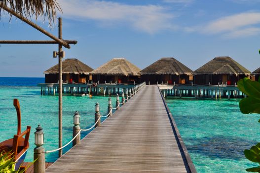 Scenic view of overwater bungalows extending over crystal clear waters, perfect for a tropical getaway.