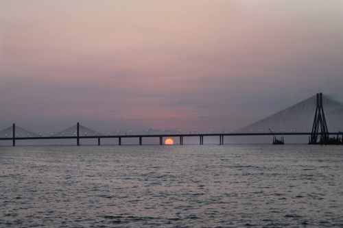 Free Scenic view of Bandra-Worli Sea Link silhouetted against a pastel sunset sky in Mumbai, India. Stock Photo