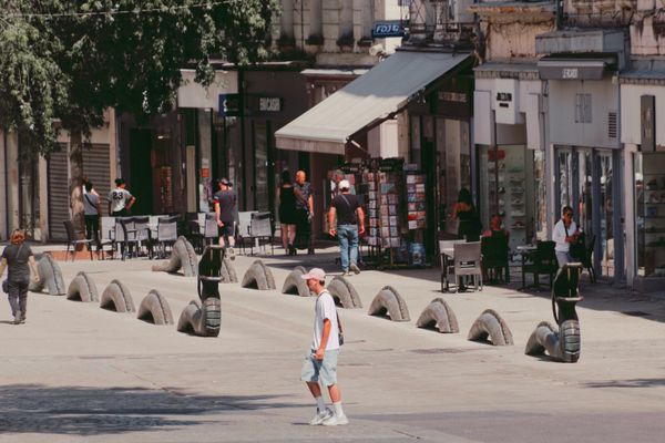Un piéton traverse une place de Niort bordée de sculptures de street art