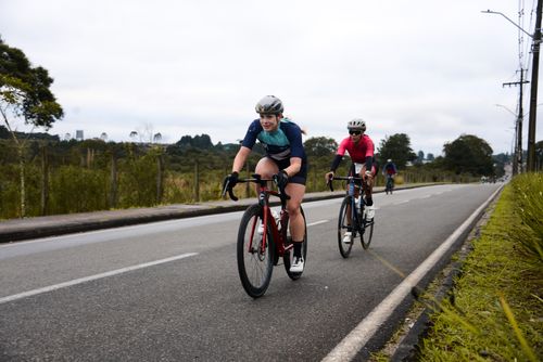 Free Athletic cyclists in vibrant gear racing on an open road in Quatro Barras, Brazil. Stock Photo
