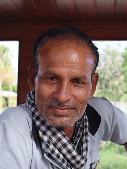 Free Portrait of a middle-aged man with a checkered scarf, smiling indoors. Stock Photo