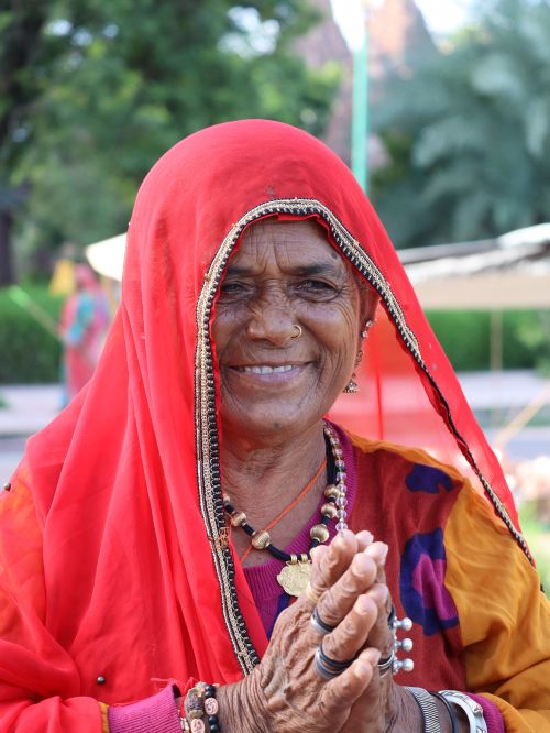 Free Senior woman in vibrant traditional Indian clothing smiling warmly outdoors. Stock Photo