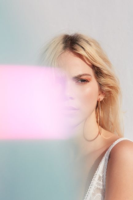 Stylized portrait of a woman with soft lighting and colorful overlay.