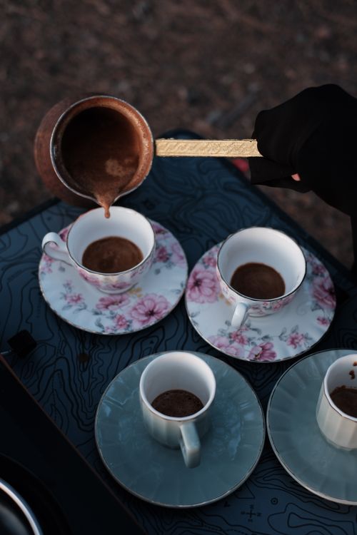 Free Aesthetic pour of Turkish coffee into elegant floral cups. Perfect for cozy outdoor gatherings. Stock Photo