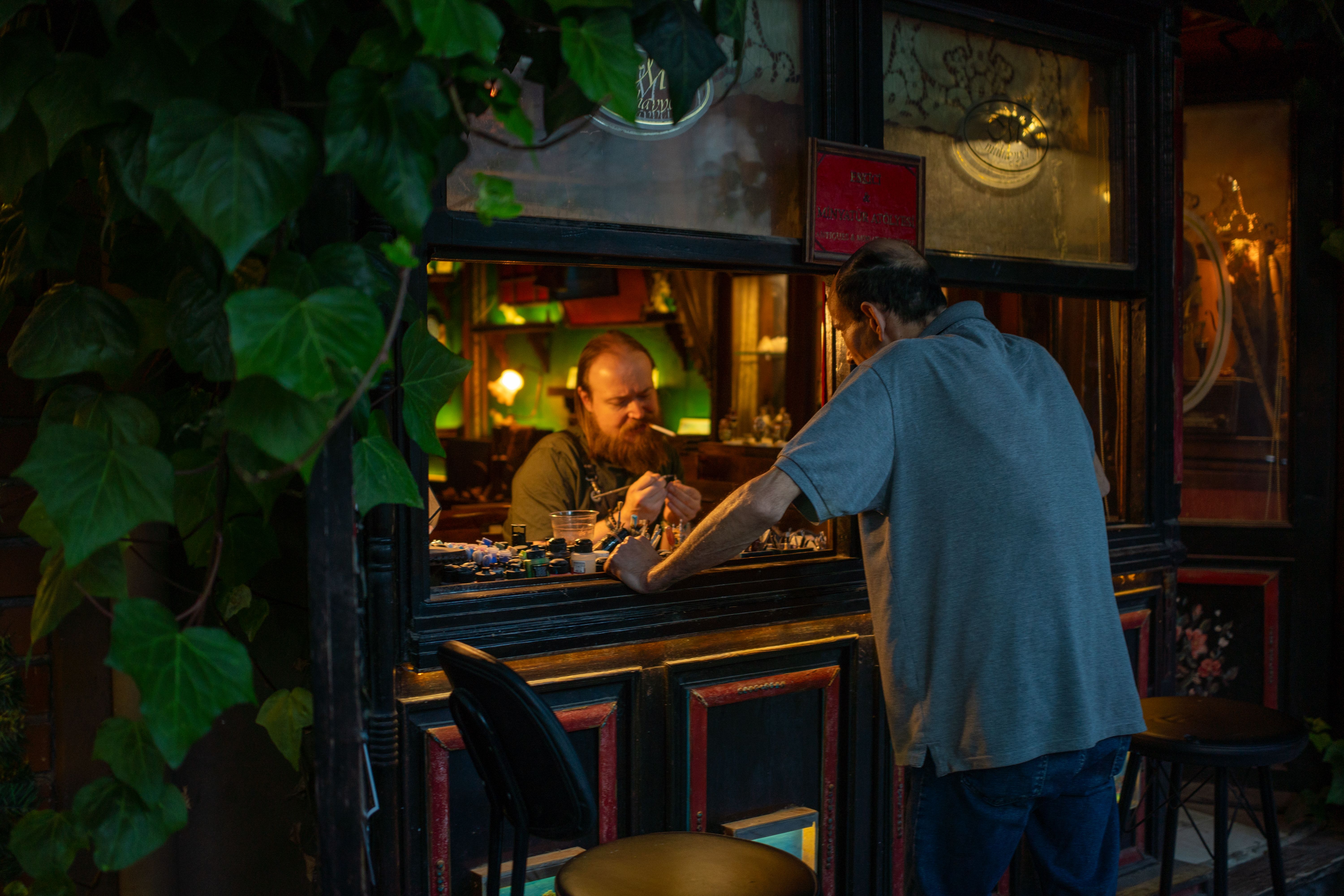 A narrow Bairro Alto street at night with people drinking outside small bars