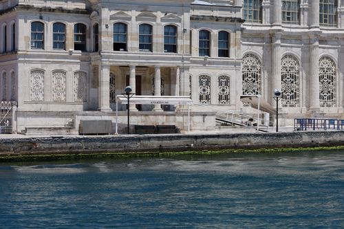 Free Elegant historic building facade with intricate designs by a serene waterfront on a sunny day. Stock Photo