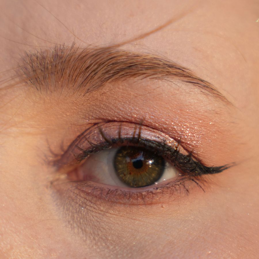 Close-up of an eye with fine, defined eyeliner along the upper lash line