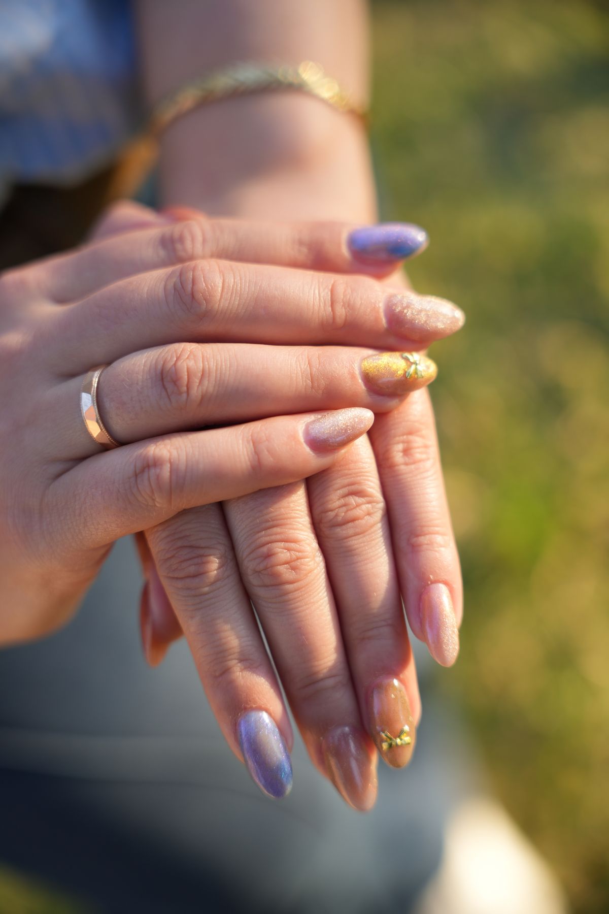 Elegant hands showcasing a vibrant multicolored manicure with unique designs.