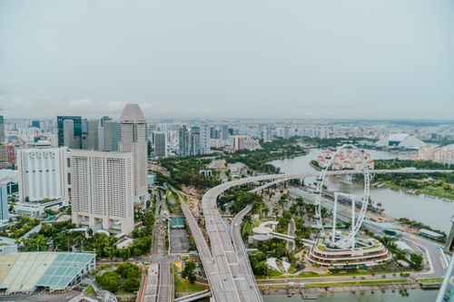 Free Stunning aerial view of Singapore cityscape featuring Marina Bay Sands and Singapore Flyer on a cloudy day. Stock Photo