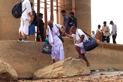 Free A diverse group navigating a rocky path, highlighting cooperation and community spirit. Stock Photo