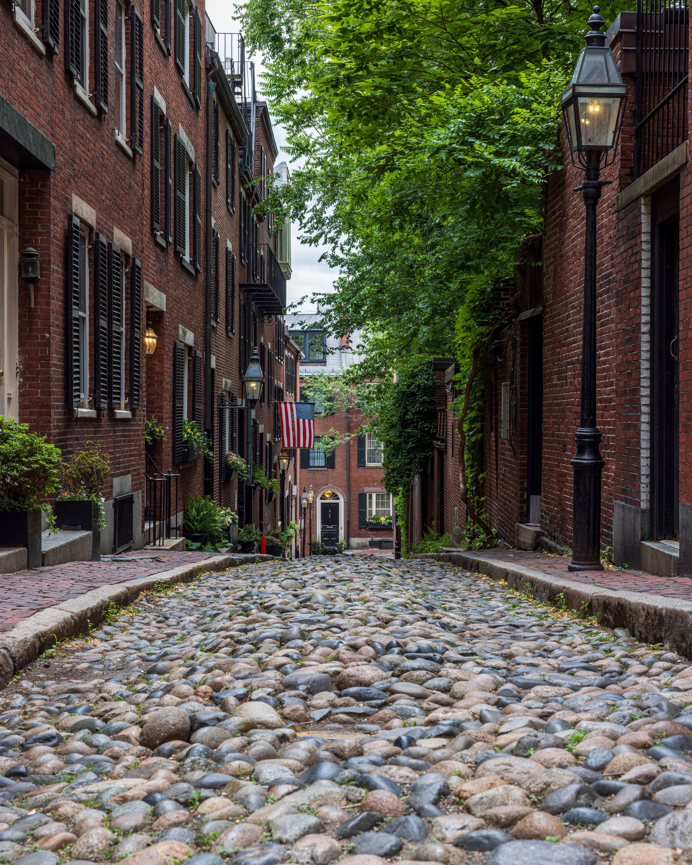 A quiet cobblestone street lined with historic brick row houses
