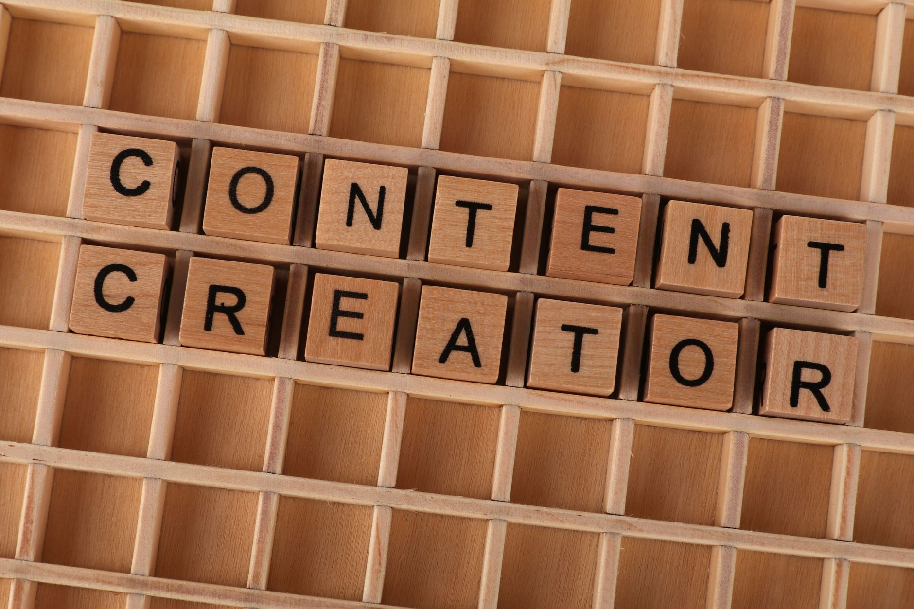 Lettres en bois formant le mot Content Creator pour illustrer l'UGC en marketing digital