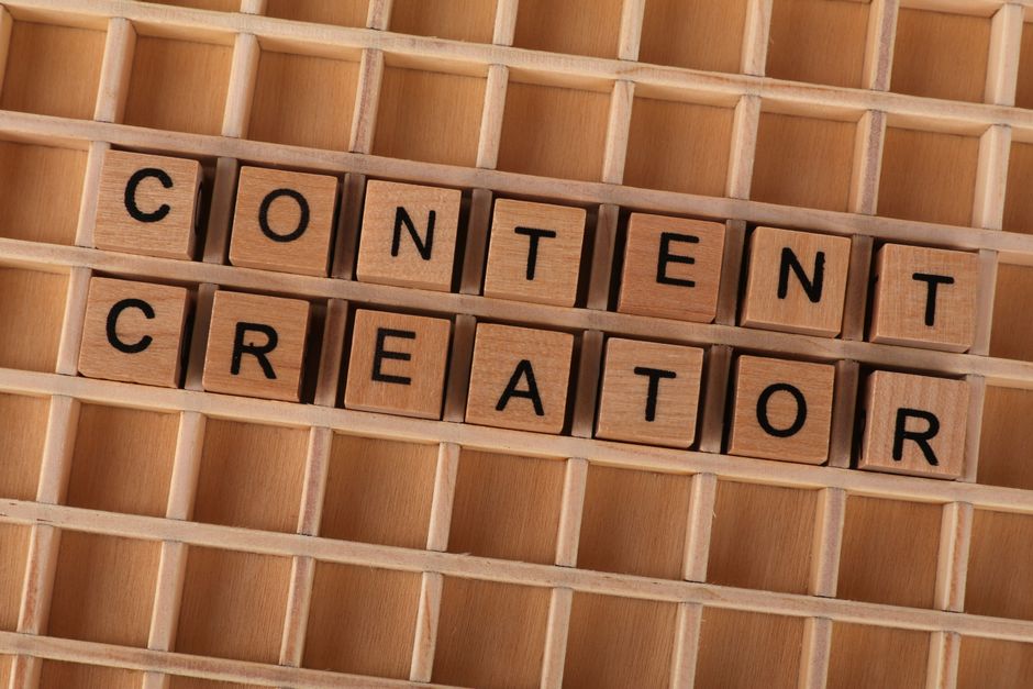 Wooden block letters spelling 'Content Creator' on a grid background. Ideal for digital marketing th