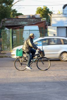 A cyclist rides through a Buenos Aires neighborhood, showcasing daily urban life.