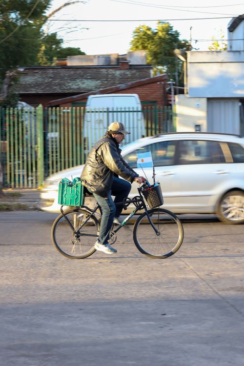 Free A cyclist rides through a Buenos Aires neighborhood, showcasing daily urban life. Stock Photo