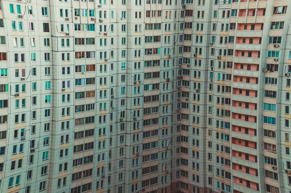 A modern high-rise building with a detailed view of multiple windows and balconies, showcasing urban architecture.