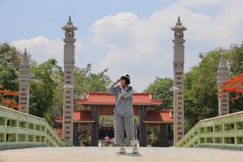 Free A young tourist on a bridge surrounded by traditional Asian temple architecture on a sunny day. Stock Photo