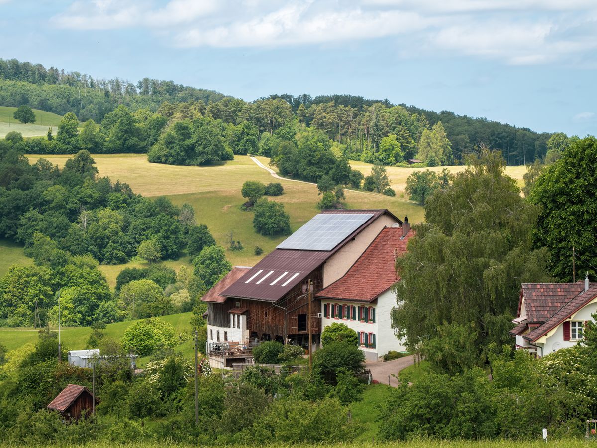 Rural farmhouse with solar panels on the roof, similar to country homes we cover in Scotland