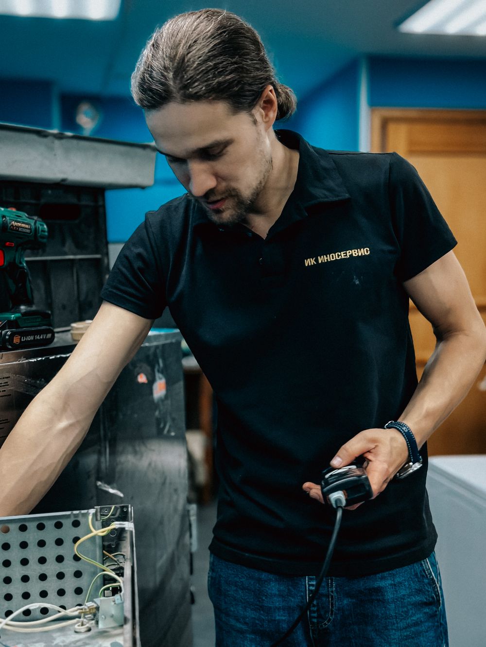 Technician repairing kitchen appliance equipment on a workbench