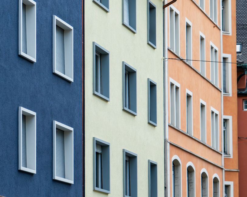 Vibrant geometric facade of city buildings featuring blue, yellow, and orange tones.