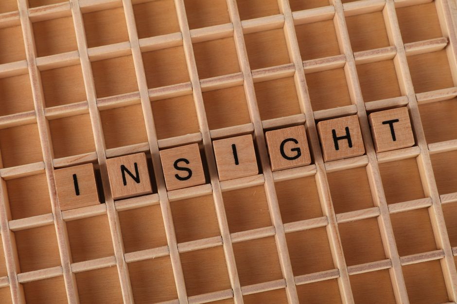 Scrabble letters spelling 'INSIGHT' on a wooden grid background, symbolizing understanding. Scrabble letters spelling 'INSIGHT' on a wooden grid background, symbolizing understanding.