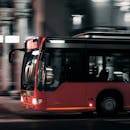 在夜间行驶的城市公交车，背景模糊，展现了城市交通